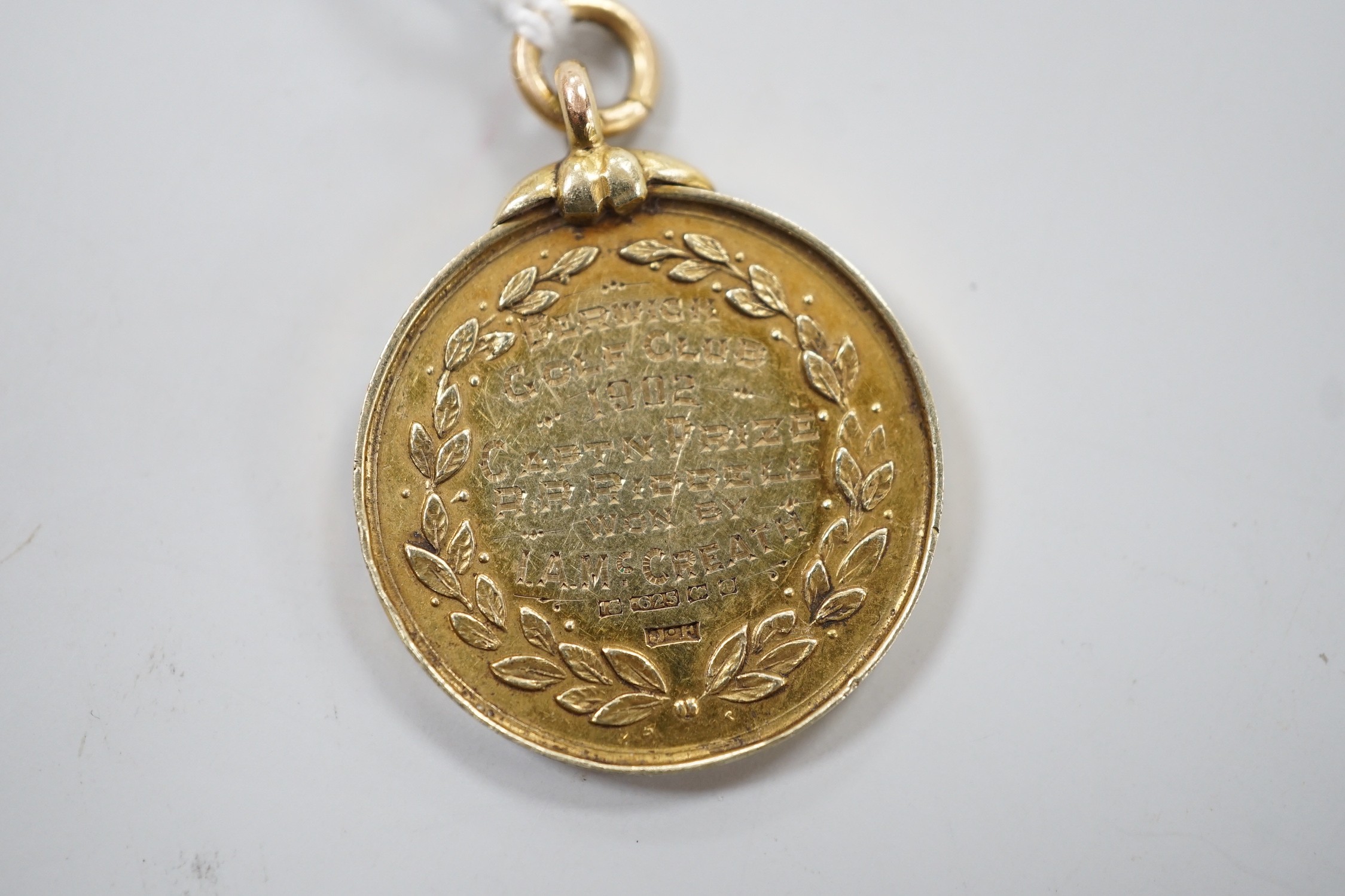 An Edwardian 15ct gold golfing medal, engraved 'Berwick Golf Club, 1902, Captn Prize R.R. Riddell won by I.A. McCreath', 26mm, 12 grams.